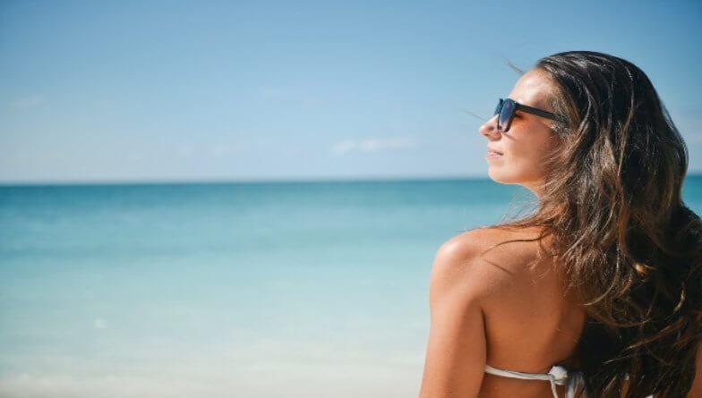 Frau am Strand schützt Augen